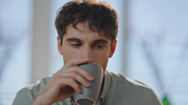 Pozorný chlap, který pije kávu v bytě sám zblízka. Portrét pohledného seriózního muže, který si doma vychutnává ranní nápoj. Pensive businessman myšlení vytváření podnikatelských nápadů uvnitř - Záběry, video