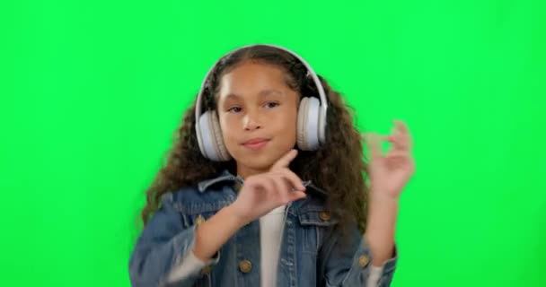 Küçük kız, yeşil ekranda dans ediyor ve müzik dinliyor mutlulukla stüdyo arka planında. Mutlu kadın, çocuk ya da kulaklıklı çocuk dans, müzik ya da müzik eşliğinde eğleniyor.. - Video, Çekim