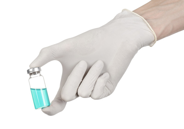 Medical theme: doctor's hand in a white glove holding a blue vial of liquid for injection isolated on white background - Valokuva, kuva