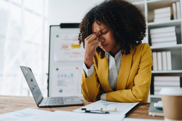 Burnout estadounidense mujer de negocios africana en estrés trabaja con muchos documentos de papeleo, ataque de migraña, independiente, trabajo en la oficina. - Foto, Imagen