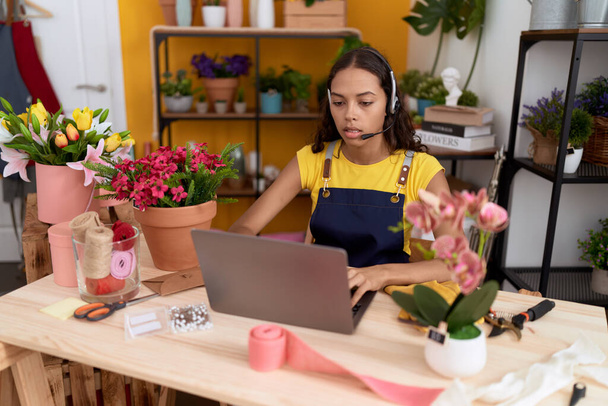 Young african american woman florist having video call at flower shop - Photo, Image