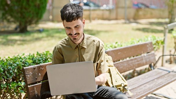 Jovem hispânico homem turista usando laptop sentado no banco no parque - Foto, Imagem
