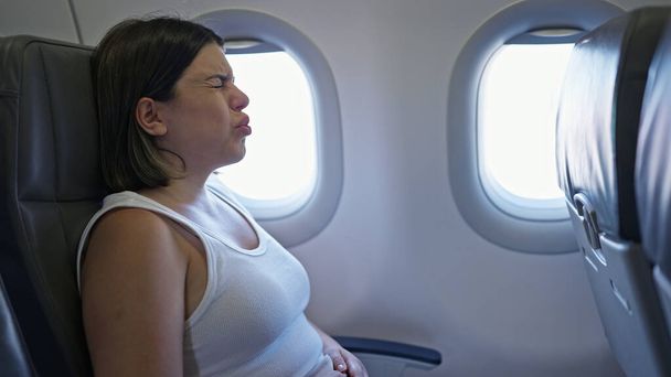 Joven mujer hispana hermosa con miedo de volar en el avión - Foto, imagen