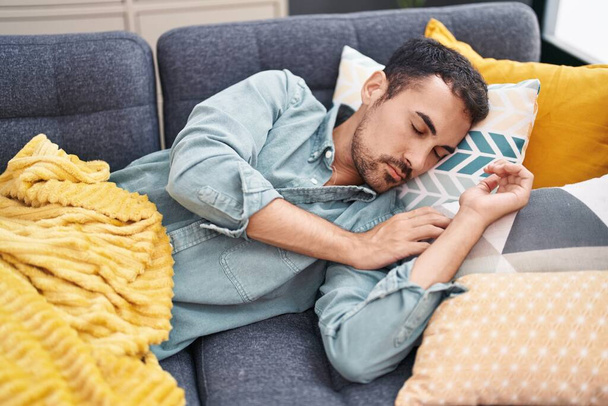 Junger hispanischer Mann liegt auf Sofa und schläft zu Hause - Foto, Bild