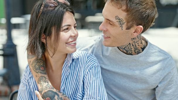 Прекрасная пара, уверенно улыбающаяся, обнимающая друг друга на террасе кафе - Фото, изображение