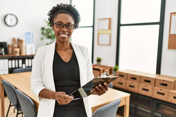Afričanky americká žena obchodní pracovník usměvavý jistý držení schránky v kanceláři - Fotografie, Obrázek