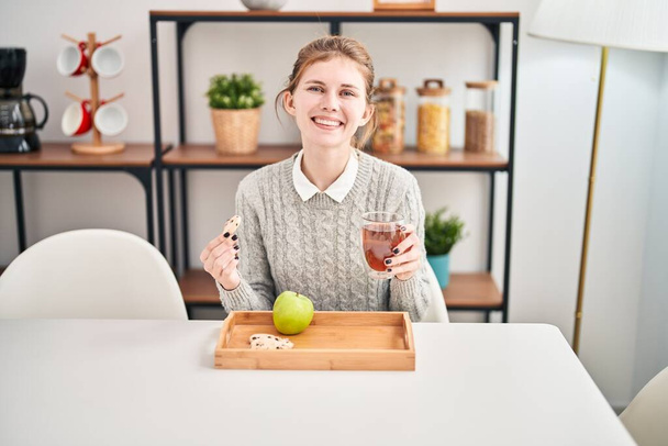 Junge blonde Frau frühstückt gesund am Tisch im Esszimmer - Foto, Bild