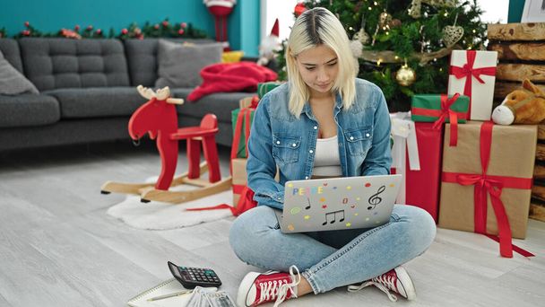 Молодая красивая латиноамериканка с ноутбуком празднует Рождество дома - Фото, изображение