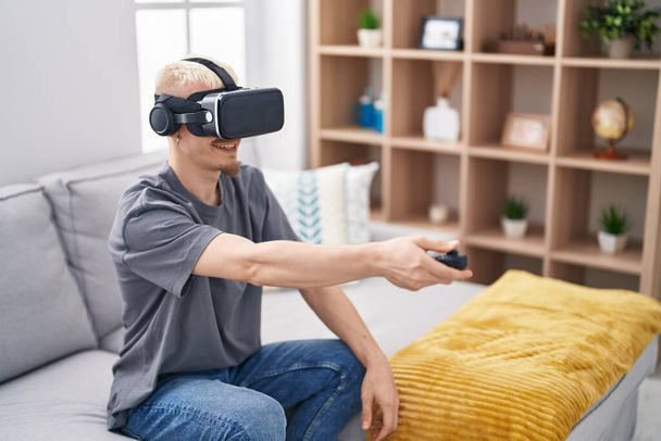 Молодий білий чоловік використовує окуляри віртуальної реальності вдома
 - Фото, зображення