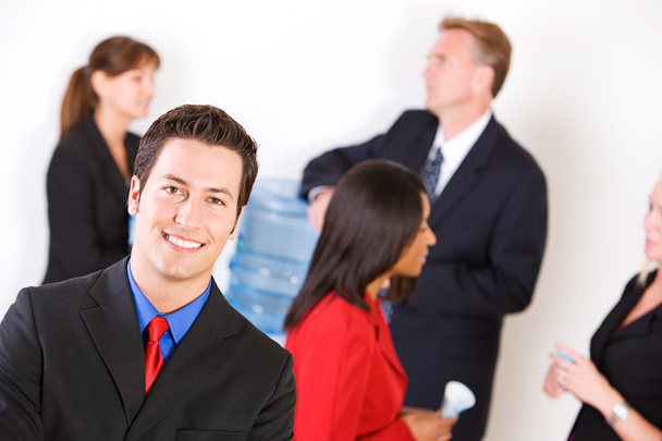 Business: Smiling Businessman with Group Around the Water Cooler - Photo, Image