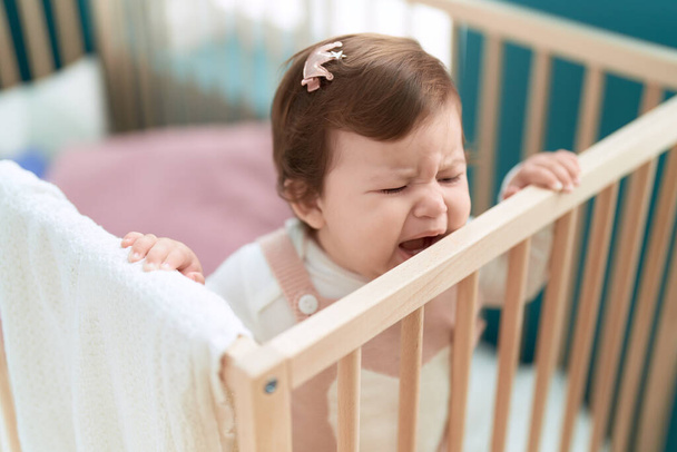 Adorable toddler standing on cradle crying at bedroom - Fotoğraf, Görsel