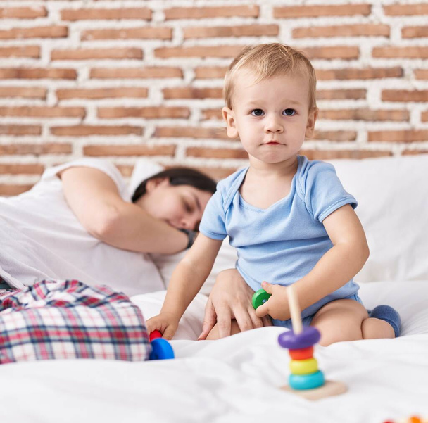 Мати і син грають на ліжку і сплять у спальні
 - Фото, зображення