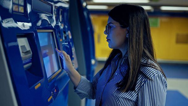 Jonge mooie Spaanse vrouw koopt metrokaartje bij de automaat in het metrostation van Madrid - Foto, afbeelding