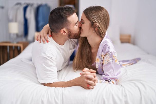 Man and woman couple lying on bed kissing at bedroom - Foto, Imagem