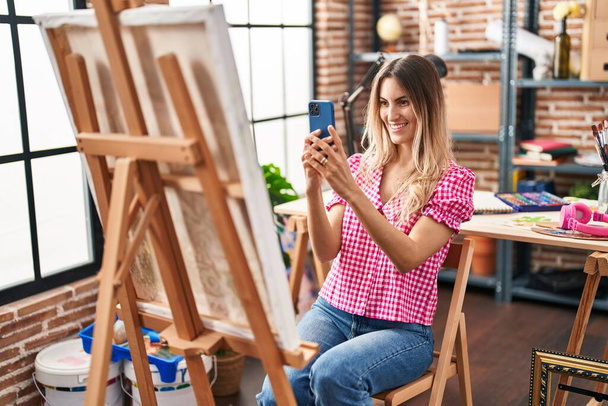 Jonge vrouw kunstenaar maken foto door smartphone te tekenen in de kunststudio - Foto, afbeelding