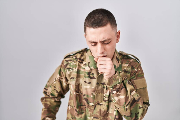 Young man wearing camouflage army uniform feeling unwell and coughing as symptom for cold or bronchitis. health care concept.  - Photo, Image