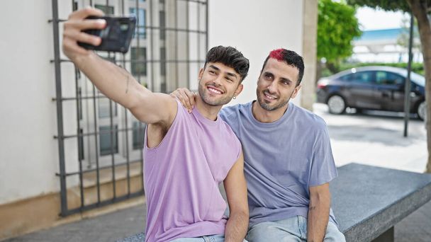 Zwei selbstbewusst lächelnde Männer machen Selfie mit dem Smartphone auf der Straße - Foto, Bild