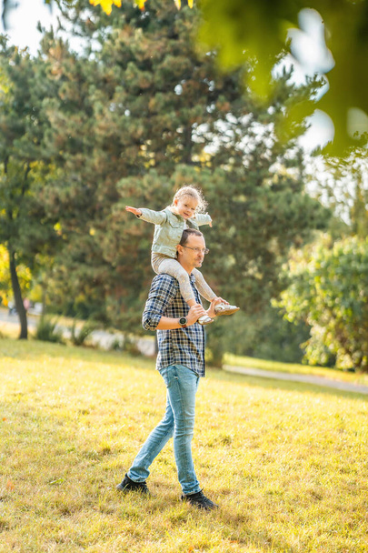 Mladý otec a zábavná dcerka se spolu baví v podzimním parku v Praze v Evropě. Kvalitní fotografie - Fotografie, Obrázek