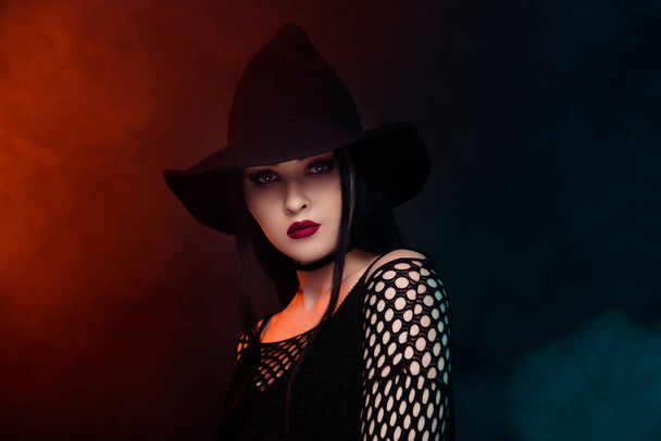 Foto van prachtige prachtige dame vieren halloween nacht evenement cosplay donkere heks over mist achtergrond. - Foto, afbeelding