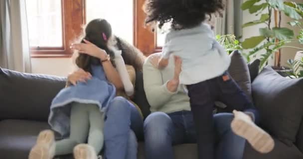 Family, parents and children hug on sofa for bonding, quality time and relaxing in living room. Happiness, playful and mother, father and kids at home having fun on couch for embrace, cuddle and love. - Footage, Video