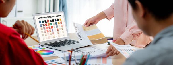 A portré a kreativitás grafikai tervező csapat válassza ki a megfelelő színt a projekt segítségével laptop asztal felszereléssel és tervezése szerszám szórás körül a modern irodában. Közelkép. Változatos. - Fotó, kép