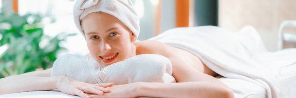 Kaunis nuori nainen rentoutuu luonnon ympäröimällä kylpylävuoteella. valmiina vartalohierontaan. Houkutteleva nainen valkoisessa pyyhkeessä makaa rauhallisesti odottaessaan kehon hierontaa. Sulje se. Rauhallisuus - Valokuva, kuva