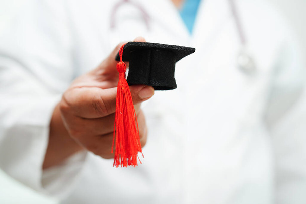 Mulher asiática médico segurando chapéu de formatura no hospital, conceito de educação médica. - Foto, Imagem