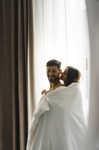 Влюбленная пара, позирующая в одеялах в горном номере отеля. Концепция отдыха в горах - Фото, изображение