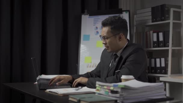 Homme d'affaires asiatique sérieux travaillant avec du papier et une calculatrice pour les documents, graphique financier, calcul de la comptabilité d'entreprise, épargne, finance et analyse de l'économie mondiale. - Séquence, vidéo