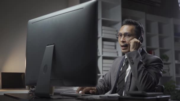 Zakenman draagt headset zittend op kantoor met behulp van desktop computer praten met klanten in video conferencing app. Hulp op afstand, virtuele ontmoeting per bedrijf, onderhandelingsconcept - Video