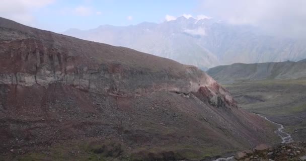 Woman alone hiking on trek path in Cacasus mountains towards Gergeti glacier Stepantsminda Georgia near Kazbek peak. - Footage, Video