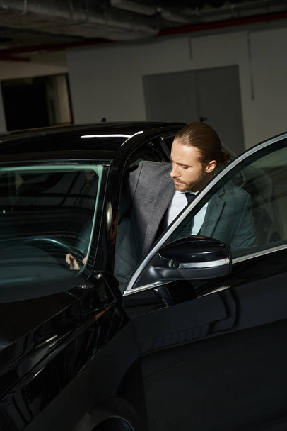 komea tyylikäs mies poninhäntä tyylikäs älykäs puku päästä hänen autonsa, liikeidea - Valokuva, kuva