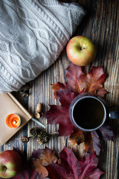 Bir fincan sıcak içecek, sonbahar yaprakları, kitaplar ve örgü kazaklar. ahşap bir arka planda - Fotoğraf, Görsel