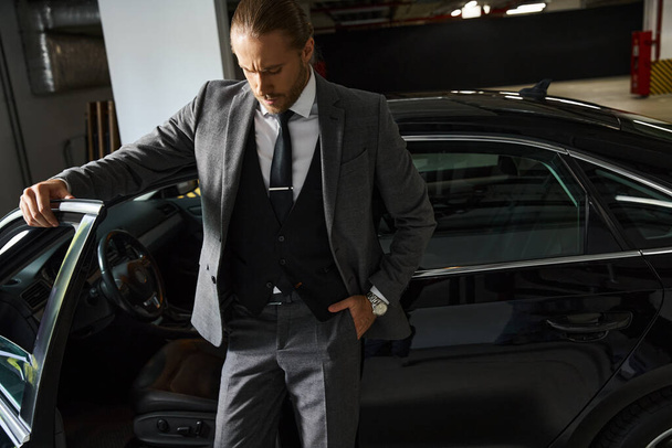 attrayant homme d'affaires élégant avec style dapper posant à côté de sa voiture avec la main dans la poche - Photo, image