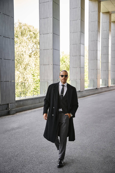 schöner rothaariger Mann mit Sonnenbrille, der mit der Hand in der Tasche nach draußen geht, Geschäftskonzept - Foto, Bild