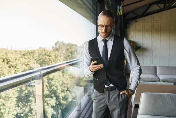 aantrekkelijke elegante man met dapper stijl op zoek naar telefoon met de hand in zak, business concept - Foto, afbeelding