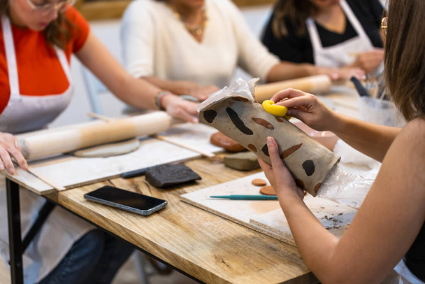 Taller de cerámica. Mujeres que trabajan en una mesa de trabajo en el taller de cerámica. - Foto, Imagen