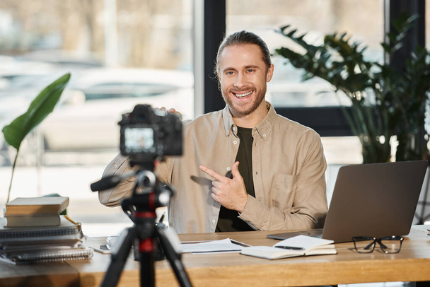 χαμογελαστός επιχειρηματίας που μιλάει μπροστά σε ψηφιακή κάμερα και καταγράφει περιεχόμενο βίντεο στο σύγχρονο γραφείο - Φωτογραφία, εικόνα