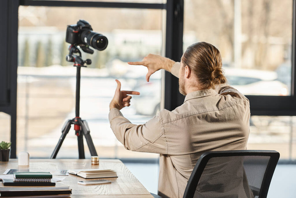 achteraanzicht van zakenman gebaren voor digitale camera op kantoor, video blogger - Foto, afbeelding