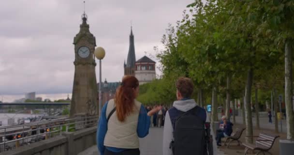 Düsseldorf, Saksa, 20. elokuuta 2023: Äiti ja poika turistit kävelevät Reinin rantaa pitkin Düsseldorfissa. - Materiaali, video