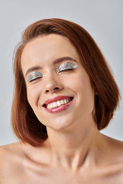 close up view of happy woman with holiday makeup and closed eyes, shiny eye shadow and red lipstick - Photo, Image