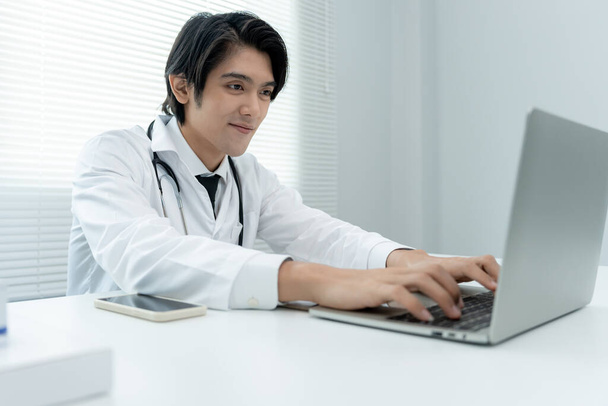 telemedical. Doctors are advising patients over the Internet by video conference. Asian doctor is treating patients through telecommunication while describing the disease . Technology for health. - Photo, Image