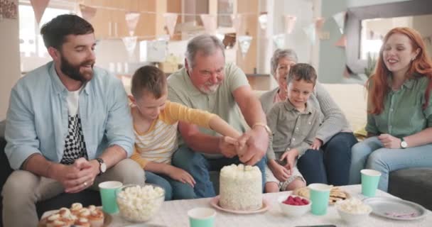 Řez, narozeninový chlapec nebo šťastná rodina s dortem na party oslavu doma s podporou nebo láskou. Babička, dědeček nebo nadšené dítě jíst pečené pouštní svačinky s tátou, matkou nebo prarodiči. - Záběry, video