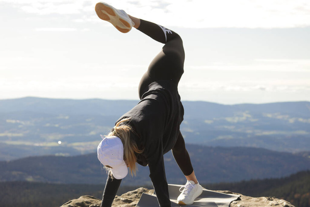 Jovem mulher atraente fazendo ioga e esporte no topo das montanhas, Yoga ao ar livre, pernas para cima, vista montanha, corpo do esporte, grupo de fitness. Meditação, relaxante, respiração profunda, alimentação saudável, corpo de equilíbrio, treinamento de fitness, vista paisagem, Alpes suíços   - Foto, Imagem