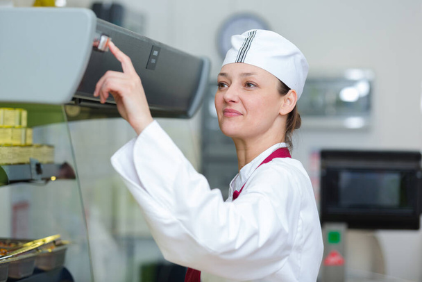 woman pressing switch on food cabinet - Valokuva, kuva