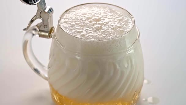 Bier wordt op een witte achtergrond in een glas gegoten. Langzame beweging. Bier. - Video