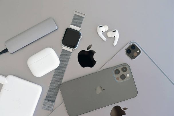 KYIV, UKRAINE - 4 MAY, 2023: Apple brand devices iphone, ipad and airpods with apple watch lies on macbook body close up - Photo, Image