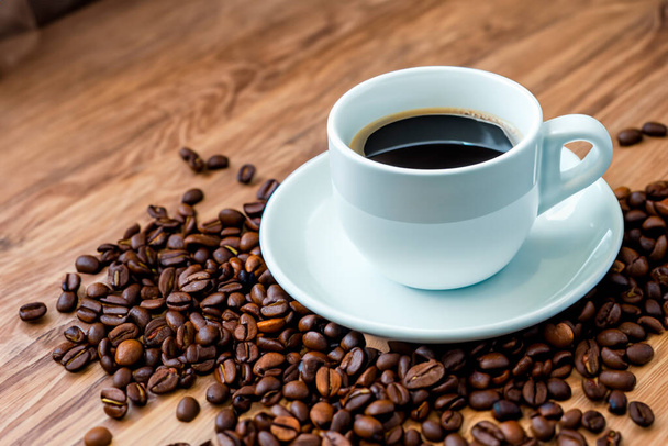 Чашка кофе и кофейных зерен на деревянном столе. Кофе. - Фото, изображение