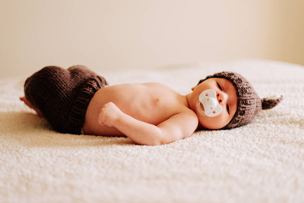 portrait of a two weeks old newborn in a costume in studio lighting - Photo, Image