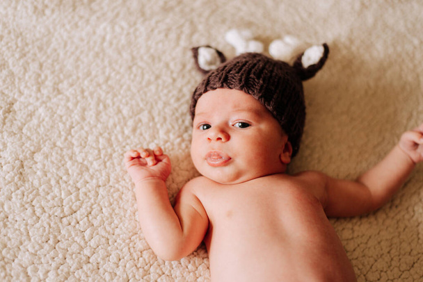 portret van een twee weken oude pasgeborene in een kostuum in studio verlichting - Foto, afbeelding